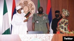 Buhari yana sakawa shugaban sojin kasa hula (Hoto: Twitter Nigerian Army)