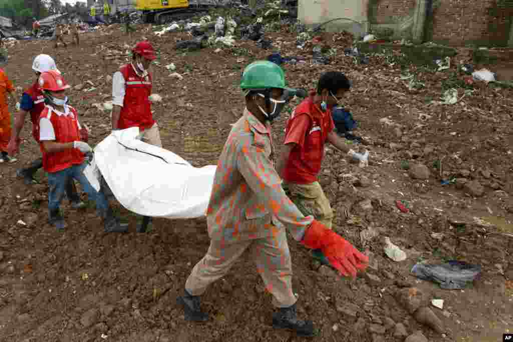 Rescuers carry the body of a victim from the rubble of a building that collapsed in Savar, Bangladesh, May 7, 2013.