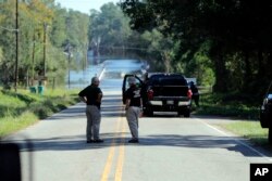 Personal de emergencia se congrega el miércoles 19 de septiembre de 2018 cerca de donde dos personas se ahogaron el martes por la noche cuando fueron atrapados en una camioneta de transporte del Sheriff del condado de Horry mientras cruzaban un puente sobre el río Little Pee Dee en la autopista 76, en el condado Marion, Carolina del Sur.