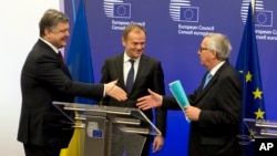 Ukrainian President Petro Poroshenko (L) is seen following a joint news conference with European Council President Donald Tusk (C) and European Commission President Jean-Claude Juncker at the EU Council building in Brussels, March 17, 2016.