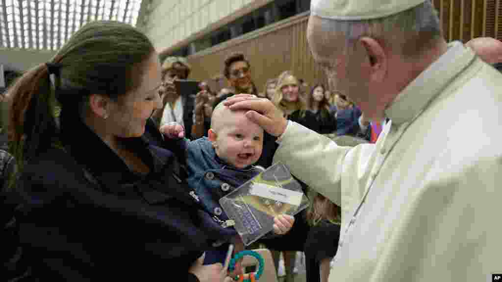 Le Pape François pose sa main sur un bébé à la fin du congrès sur les progrès de la médecine régénérative, 29 avril 2016.
