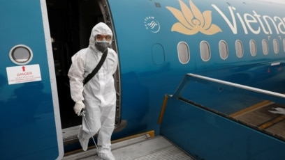 Một nhân viên Vietnam Airlines tẩy trùng máy bay.