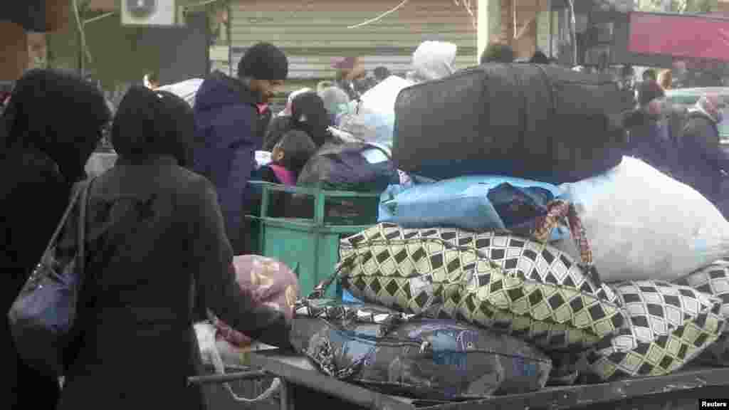 Eastern Aleppo residents wait in the streets to be evacuated from the war-torn city of Aleppo, Syria, Dec. 15, 2016.