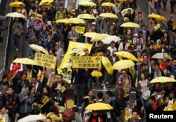 FILE - Protesters carrying yellow umbrellas, the symbol of the Occupy movement, march on a street in Hong Kong, Feb. 1, 2015.
