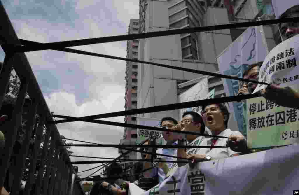 Pro-democracy protesters display black ribbons in front of the Chinese central government&#39;s liaison office in Hong Kong. One of the five Hong Kong booksellers whose disappearances sparked international concern said Thursday he spent months confined in a room under constant surveillance by mainland Chinese authorities.