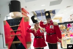 In this Tuesday, Nov. 13, 2018 photo, FAO Schwarz toy soldiers dressed in uniforms designed by model Gigi Hadid pose for a photo during a media preview of the new FAO Schwarz store at Rockefeller Center in New York. (AP Photo/Mary Altaffer)