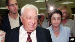 FILE - Israeli Likud party leader Ariel Sharon accompanied by his wife Lily, right, walks in to the Knesset building in Jerusalem before his appointment to the post of Minister of Infrastructure, July 8, 1996.