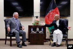 FILE - Secretary of State Rex Tillerson, left, speaks with Afghan President Ashraf Ghani before their meeting, Oct. 23, 2017, at Bagram Air Field, Afghanistan.