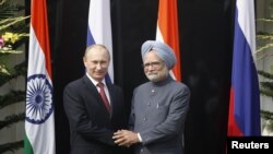 ທ່ານ Vladimir Putin ປະທານາທິບໍດີຣັດເຊຍ ຈັບມືກັບທ່ານ Mohmohan Singh ນາຍົກລັດຖະມົນຕີອິນເດຍ ກ່ອນເລີ້ມຕົ້ນ ພົບປະກັນ ທີ່ເຮືອນພັກຂອງນາຍົກລັດຖະມົນຕີ ອິນເດຍ ຢູ່ນະຄອນຫລວງນີວແດນລີ ໃນວັນທີ 24 ທັນວາ 2012 REUTERS/Mustafa Quraishi/Pool (INDIA - Tags: POLITICS)