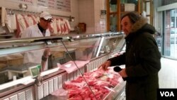 Butcher Abdel Haq takes a question from a customer at Boucherie de l'Argonne, in Paris, Feb. 3, 2016. ( L. Bryant/VOA)