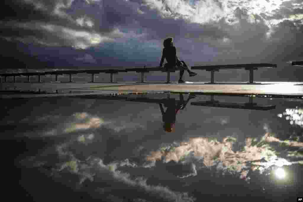 A woman sits in front of the sea after a storm in Barcelona, Spain.