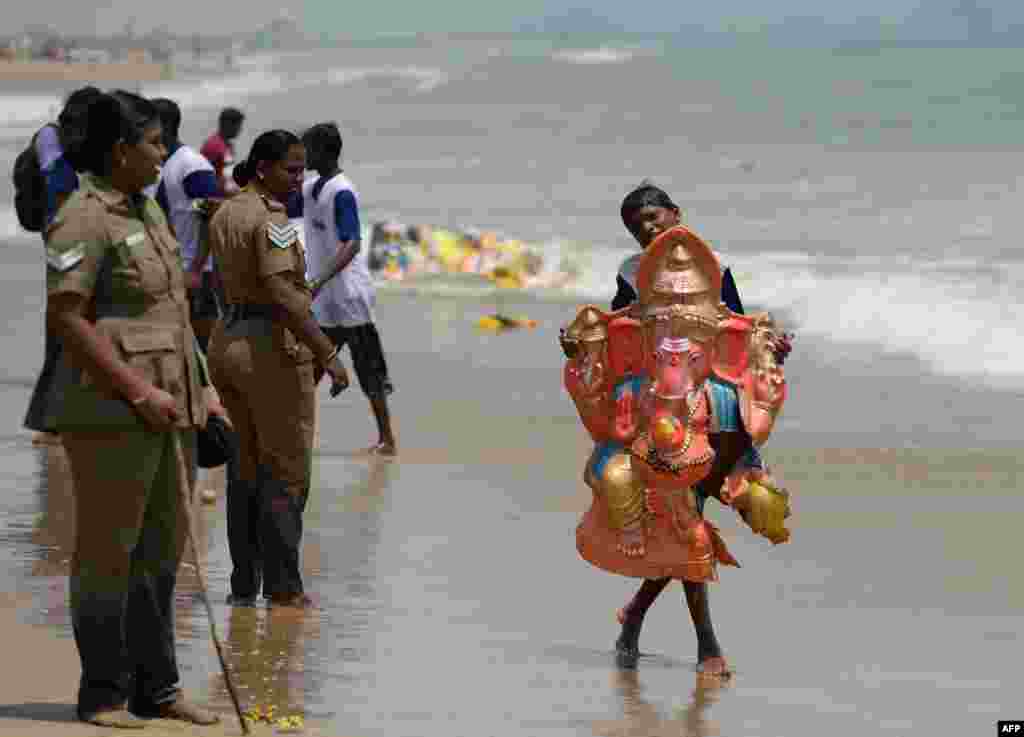 Devotees carry an idol of the elephant-headed Hindu god Ganesh for immersion in the Indian ocean at Pattinapakkam beach in Chennai, India, as part of Ganesh Chaturthi festival.