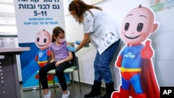 Gadis Israel Danae Vitkin (9), menerima vaksin Pfizer-BioNTech COVID-19 pertamanya dari staf medis di layanan Kesehatan Clalit di Tel Aviv, Israel, Selasa, 23 November 2021. 