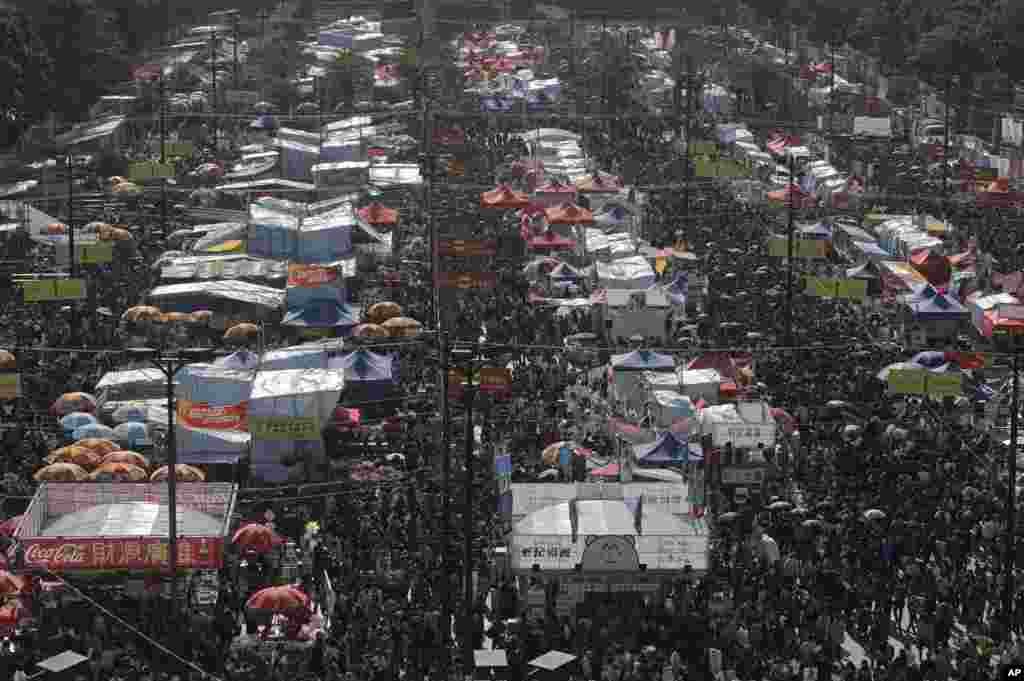 Warga memadati pasar Tahun Baru di Taman Victoria, Hong Kong, untuk membeli bunga dan dekorasi Imlek (27/1). (AP/Vincent Yu)