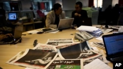 FILE - Egyptian journalists work in the editorial room of the Al-Masry Al-Youm daily newspaper next to copies of Egypt’s most prominent newspapers in Cairo, Egypt, Dec. 3, 2012. 