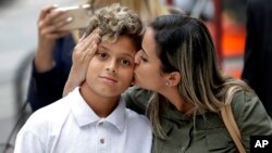 Sirley Silveira Paixao, an immigrant from Brazil seeking asylum, kisses her 10-year-old son Diego Magalhaes after he was released from immigration detention in Chicago, July 5, 2018. 