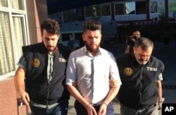 Turkish police officers escort a man arrested in a raid in Konya, Turkey, July 12, 2017. Police killed five Islamic State militants in a firefight that erupted during a raid on a house in the central city of Konya, officials said.