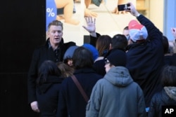 Josh Homme, a member of the band Eagles of Death Metal, waves to fans as he arrives ahead of his concert at the Olympia music hall, in Paris, Feb. 16, 2016.