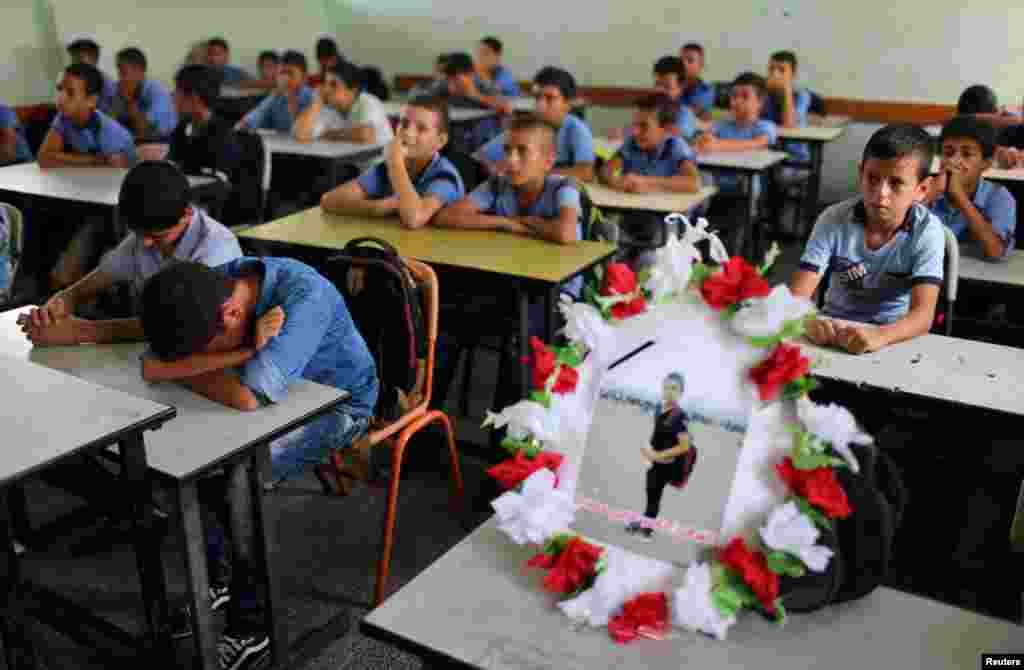 A picture of 12-year-old Palestinian boy Nassir al-Mosabeh, who was killed during a protest at the Israel-Gaza border fence, is seen on his table as his classmates react at a school, in Khan Younis in the southern Gaza Strip.