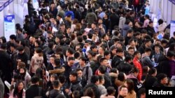 FILE - Students are seen at a job fair for graduates at a university in Shenyang, Liaoning province, China, March 21, 2019. 