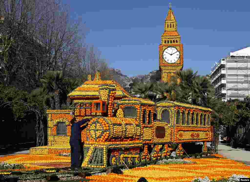 A worker puts the final touch to a train near a replica of Big Ben made with lemons and oranges during the 80th Lemon festival in Menton, France. Some 145 metric tons of lemons and oranges are used to make displays during the festival, which is themed &#39;Around The World In 80 Days&#39;, and runs from February 16 through March 6.
