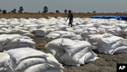 FILE - Bags of food dropped by air from a World Food Program plane are sorted in Padeah, South Sudan. South Sudanese who fled famine and fighting in Leer county emerged from South Sudan's swamps after months in hiding to receive food aid.