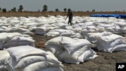 Bags of food dropped by air from a World Food Program plane are sorted in Padeah, South Sudan. South Sudanese who fled famine and fighting in Leer county emerged from South Sudan's swamps after months in hiding to receive food aid.