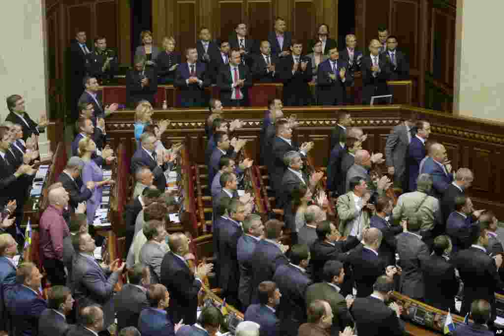 Ukrainian lawmakers applaud after ratifying an agreement to deepen economic and political ties with the European Union in Kyiv, Ukraine, Sept. 16, 2014.