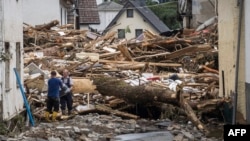 Ljudi uklanjaju ruševine kuća uništenih u poplavama u Šuldu, u blizini Bad Nojenara, na zapadu Njemačke.