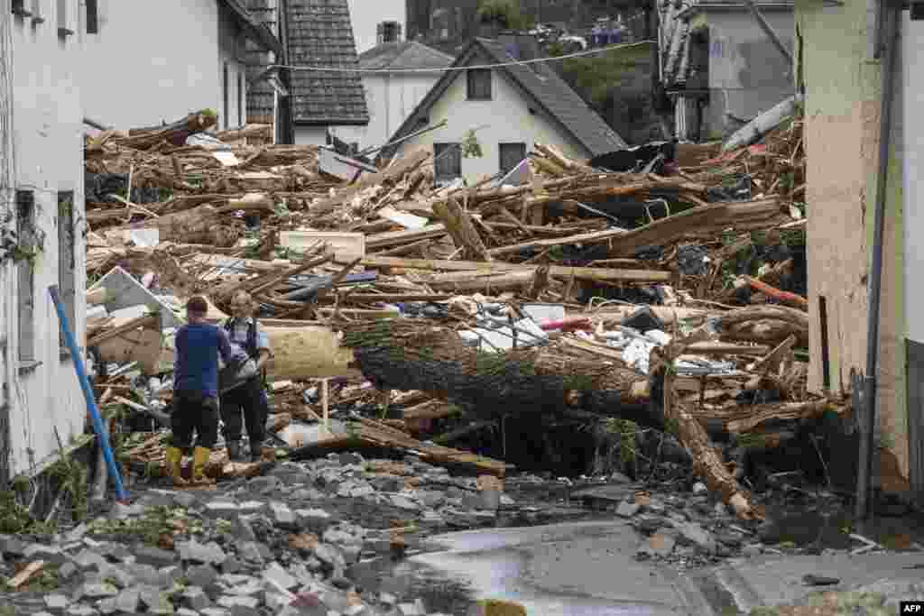 Two men remove debris of houses destroyed by the floods in Schuld near Bad Neuenahr, western Germany. Heavy flooding turned streams and streets into raging torrents, sweeping away cars and causing some buildings to collapse.