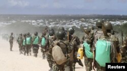 FILE - African Union Mission in Somalia (AMISOM) peacekeepers from Burundi patrol after fighting between insurgents and government soldiers erupted on the outskirts of Mogadishu, May 22, 2012.