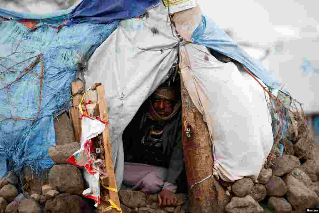 A man sits in his hut at a camp for internally displaced people near Sana&#39;a, Yemen.