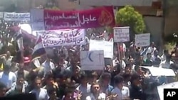 An image grab taken from YouTube shows Syrian anti-regime protesters marching during a rally in the northeastern city of Kafr Nabl, June 3, 2011