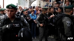Israeli security troops block Christian pilgrims along the Via Dolorosa (Way of Suffering) in Jerusalem’s Old City during the Good Friday procession on March 25, 2016.