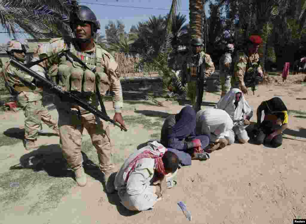 Iraqi soldiers arrest suspected militants during a raid and weapons search operation in North Babil province, Oct. 27, 2013. 