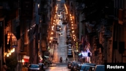 A street in downtown Rome glows with the warm light of the old sodium lightbulbs. Rome is in the process of swapping out the older lights for new, more efficient LED lights.