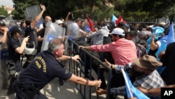 Riot police use pepper spray to push back a group of Uighur protesters who try to break through a barricade outside the Chinese Embassy in Ankara, Turkey, June 9. 2015. 