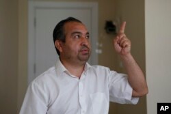 Mahmut Tevekkul, an ethnic Uyghur who fled from China to Turkey, gestures as he talks to The Associated Press in Istanbul, Wednesday, June 2, 2021. (AP Photo/Mehmet Guzel)