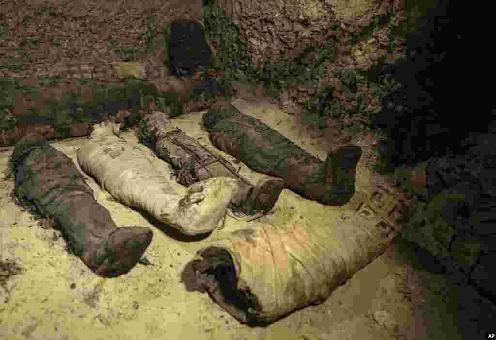 Mummies lie in a recently discovered burial chamber in the desert province of Minya, south of Cairo, Egypt, Feb. 2, 2019. Egypt announced that it found a number of ancient burial chambers cut in rock, with about 40 mummies that are in good shape, along with pottery, papyri and exquisite mummy cases.