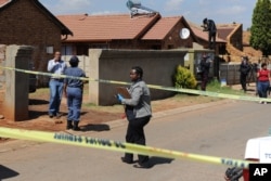 Police, forensic investigators and press work outside the home of actress and singer, Kelly Khumalo, in Vosloorus, east of Johannesburg, South Africa, Oct. 27, 2014.