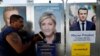 Campaign posters of French National Front (FN) political party leader Marine Le Pen (C) and head of the political movement En Marche! (Onwards!) Emmanuel Macron (R), are seen in Antibes, France, April 14, 2017.