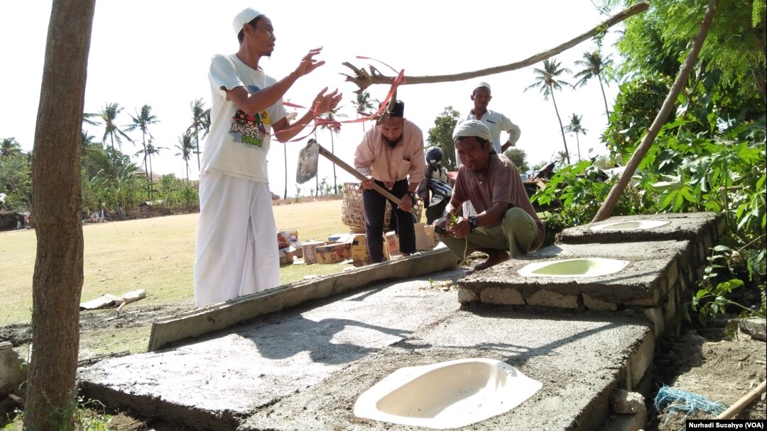 Pengungsi di Pemenang, Lombok Utara, membangun toilet baru di tepi lapangan tempat mereka mengungsi.