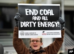 A protestor holds a sign demanding to end coal burning during the 23rd Conference of the Parties (COP) climate talks in Bonn, Germany, Nov. 15, 2017.