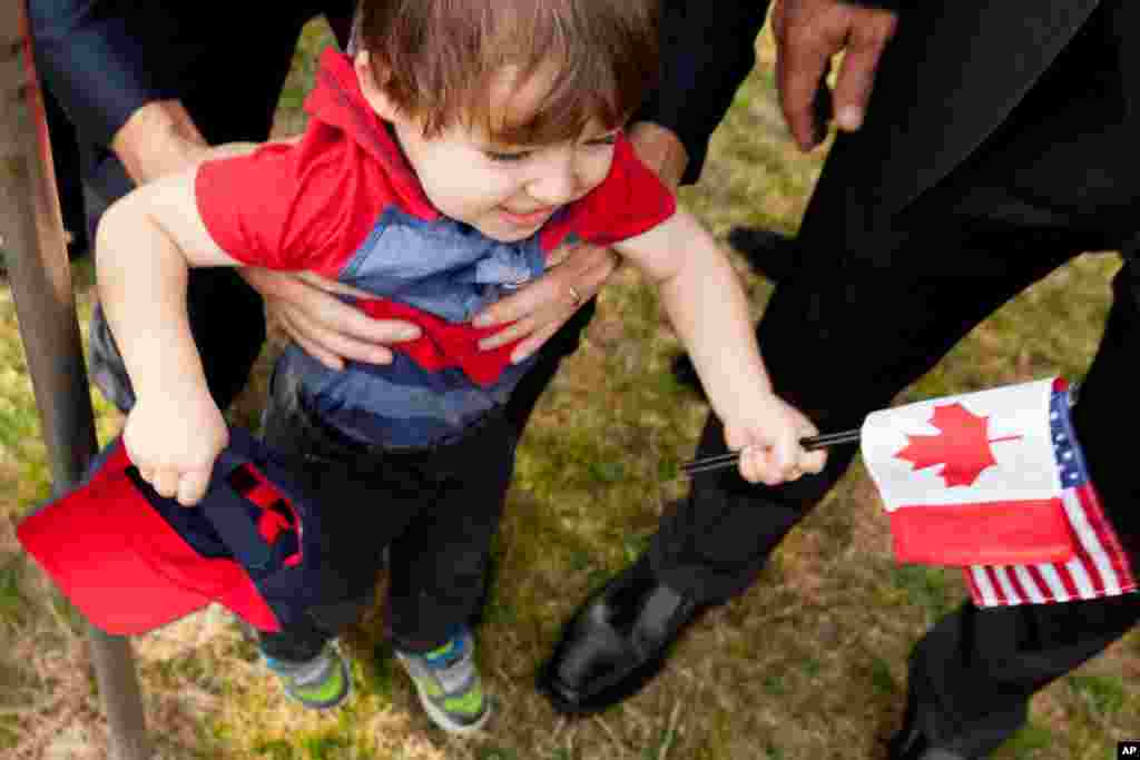 A boy in the audience holds Canadian and American flags before President Barack Obama greets Canada’s Prime Minister Justin Trudeau, for an arrival ceremony on the South Lawn of the White House, March 10, 2016.