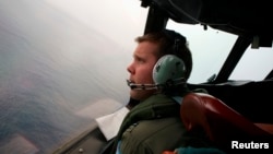 Co-Pilot, Flying Officer Marc Smith, turns his Royal Australian Air Force (RAAF) AP-3C Orion aircraft at low level in bad weather whilst searching for the missing Malaysian Airlines Flight MH370 over the southern Indian Ocean, March 24, 2014.