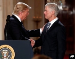 FILE - President Donald Trump shakes hands with 10th U.S. Circuit Court of Appeals Judge Neil Gorsuch, his choice for Supreme Court associate justice in the East Room of the White House in Washington, Jan. 31, 2017.