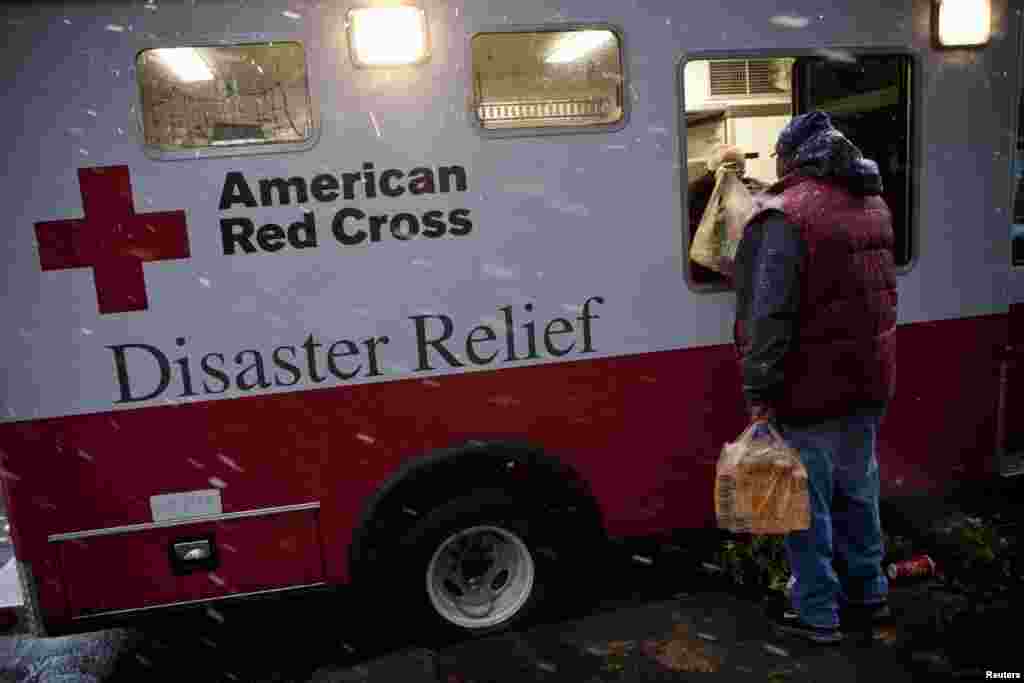 Žrtva uragana Sandy prima pomoć u hrani iz vozila Crvenog križa nakon nove oluje. New York, 7. novembra 2012. 