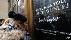 Women peer in the front door of Lord & Taylor's flagship Fifth Avenue store which closed for good, Jan. 2, 2019, in New York. 