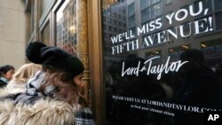 Women peer in the front door of Lord & Taylor's flagship Fifth Avenue store which closed for good, Jan. 2, 2019, in New York.