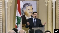 Lebanese caretaker Prime Minister Saad Hariri speaks during a press conference with a poster of his slain father Rafik Hariri in the background, in Beirut, Jan. 20, 2011